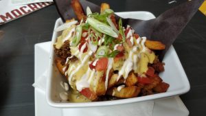 vegan fries surpreme, democracy hamilton fries, topped with vegan cheese, sour cream, tomatoes, green onions, and vegan meat