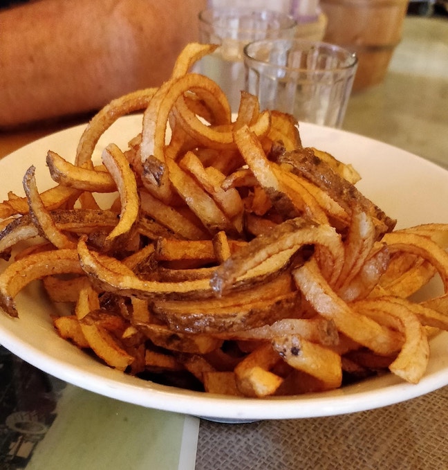 hand cut spiral fries, in a white bowl