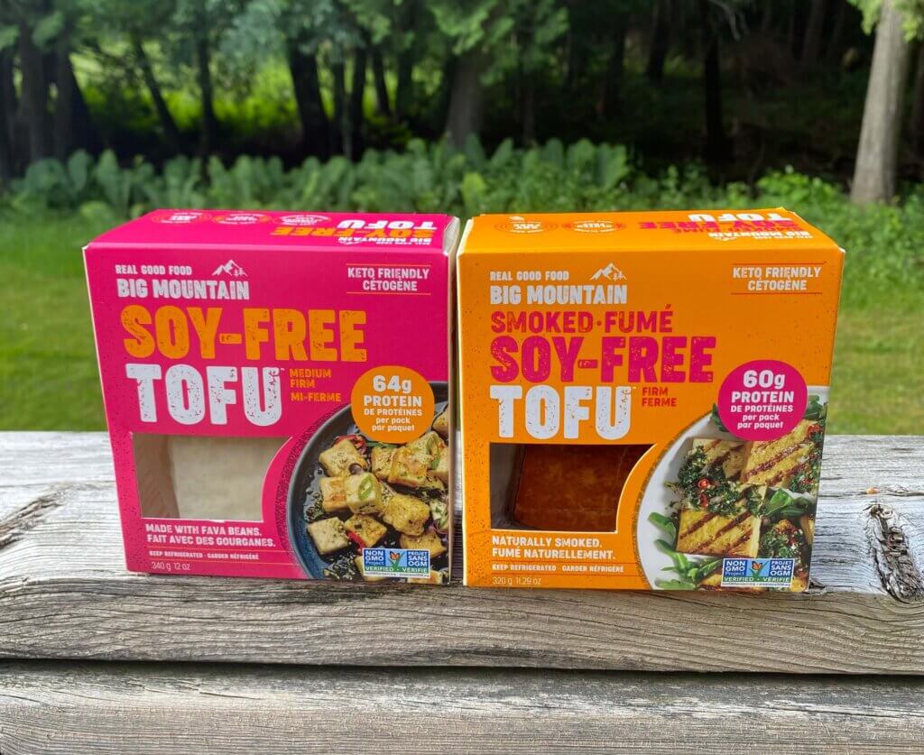 Two boxes of Soy-Free Tofu on an outdoor space. There is one box that is smoked, and one box that is regular. 